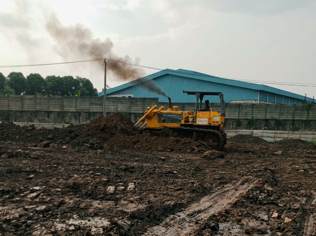 Bulldozer mendorong timbunan tanah.