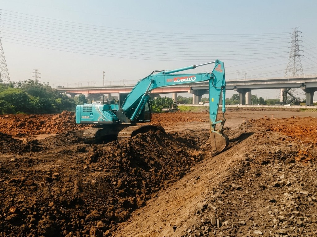 Ekskavator menggali tanah di lokasi pekerjaan.